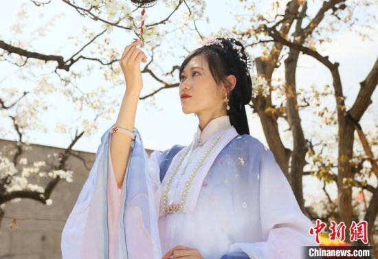 圖為蘭州青年身穿漢服在百年梨園賞景?！「哒?攝