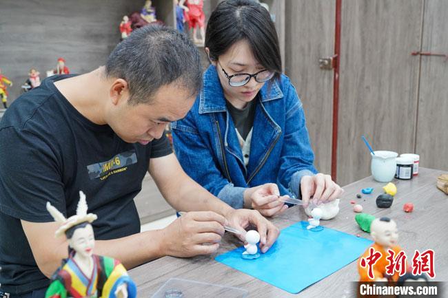 <a target='_blank'  data-cke-saved- >中新社</a>記者(右)現(xiàn)場(chǎng)體驗(yàn)面塑制作過(guò)程?！￡悹?zhēng)強(qiáng) 攝