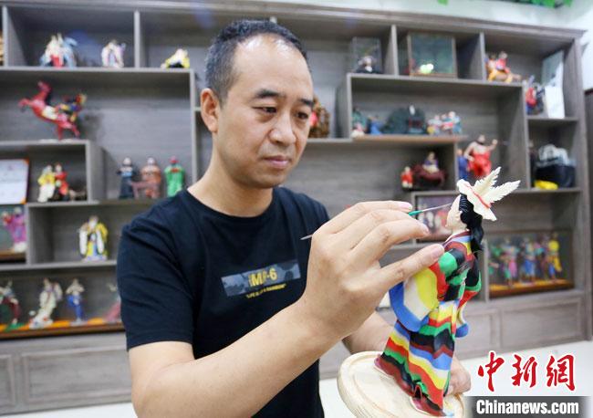 圖為安秋平正在創(chuàng)作代表隴南文縣民俗的《白馬人》作品?！「哒?攝