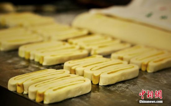 圖為面劑被涂上胡麻油，切成條狀用作月餅的花型制作。張文 攝