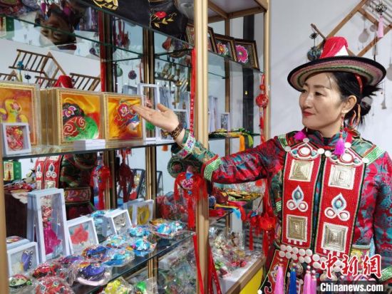 圖為身著民族服飾的隴原巧手展示手工藝品。(資料圖) 徐雪 攝