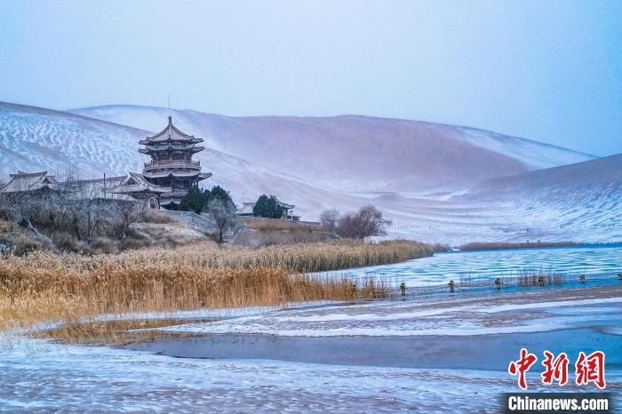2021年11月28日，雪落鳴沙山月牙泉景區(qū)?！⊥醣筱y 攝