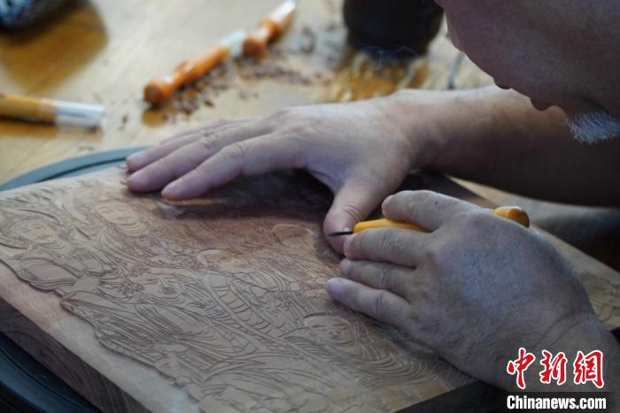 圖為徐晉林湊近木板，近距離制作雕版畫?！【琶赖┰?　攝