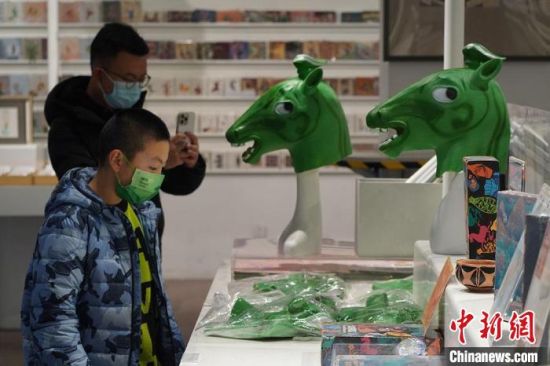 圖為“神馬來了”銅奔馬頭套吸引參觀者駐足?！【琶赖┰?攝
