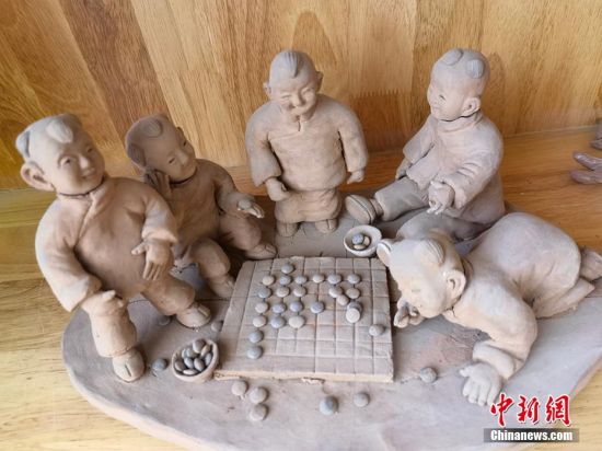 圖為泥塑作品展現(xiàn)下棋場(chǎng)景。 劉玉桃 攝