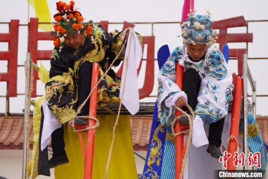 圖為“苦水高高蹺”表演者通過麻繩將腳固定在腳踏板，并在腿部纏繞六七圈?！【琶赖┰?攝