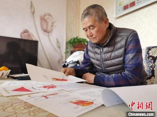 圖為陸鵬飛向記者展示多年帶隊(duì)的手寫筆記?！堟?攝