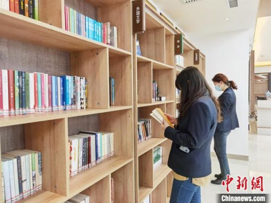 圖為在甘肅公航旅建設(shè)集團(tuán)有限公司的職工書屋，職工挑選書籍?！⌒煅?攝