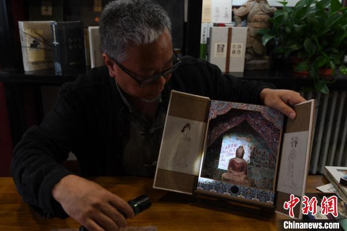 圖為讀者出版集團(tuán)讀者晉林工作室獨立出品人徐晉林，展示互動性強的敦煌題材手工書。(資料圖) 楊艷敏 攝