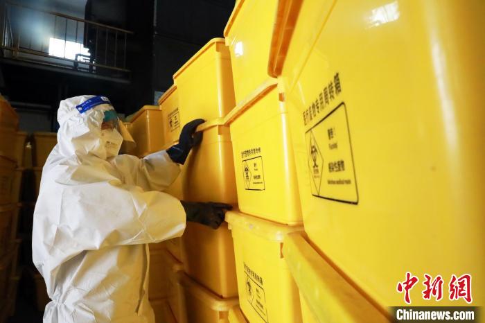 圖為工作人員搬運醫(yī)療廢物專用周轉(zhuǎn)箱?！∥航ㄜ?攝