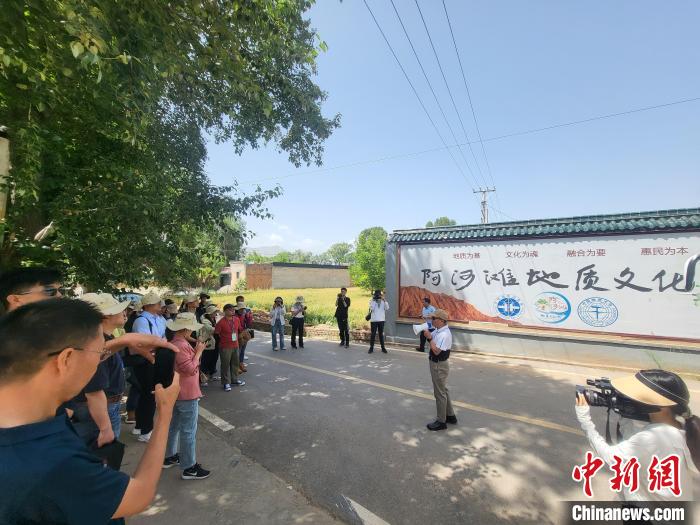 圖為中國地質(zhì)大學(xué)(北京)教授張緒教介紹村落情況?！『衍?攝