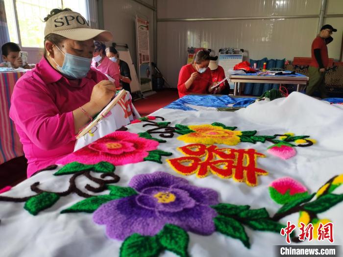 圖為婦女制作青繡?！?zhí)砀?攝