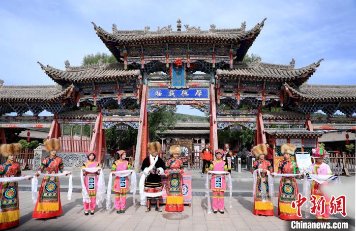 圖為身穿土族服飾的工作人員迎接訪客?！⊙Φ?攝