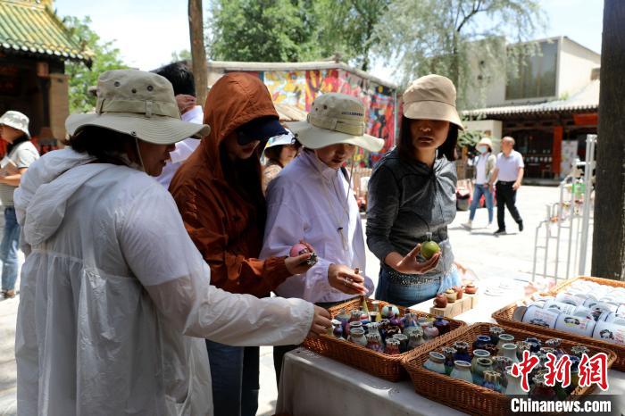 圖為民眾挑選手工藝產(chǎn)品?！⊙Φ?攝