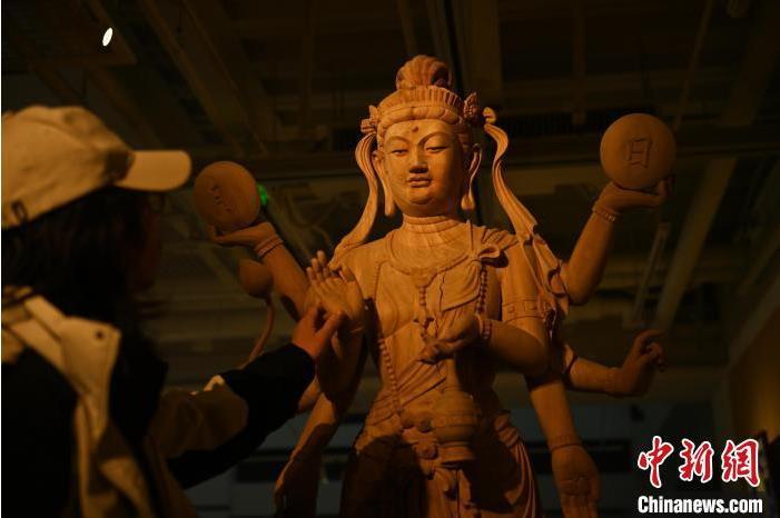 圖為季茂杰觀察自己創(chuàng)作的敦煌木雕。李亞龍 攝</p>
<p>