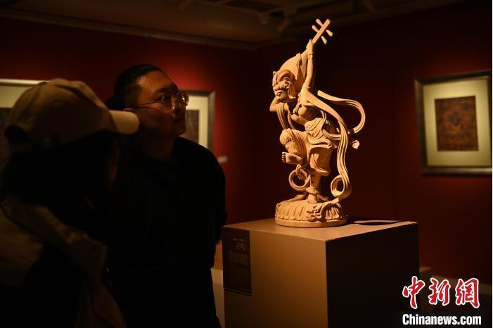 圖為季茂杰向參觀者介紹自己創(chuàng)作敦煌木雕的過程。李亞龍 攝</p>
<p>