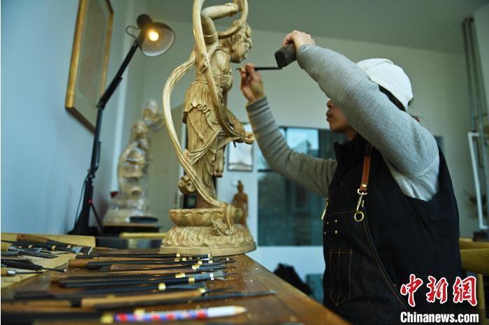 圖為季茂杰進行敦煌元素的木雕創(chuàng)作。李亞龍 攝</p>
<p>