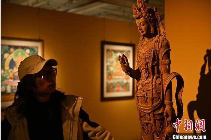 圖為季茂杰觀察自己創(chuàng)作的敦煌木雕。李亞龍 攝</p>
<p>