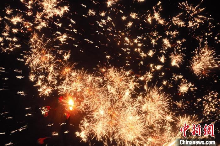 灼熱的鐵水在空中迸散。在空中形成“鐵花火雨”的景象，似天女散花，似群星漫天，如夢如幻，美不勝收。侯奇志 攝</p>
<p>