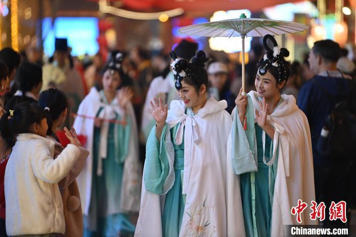 圖為街區(qū)人員著傳統(tǒng)服飾與游人互動(dòng)。李亞龍 攝</p><p>