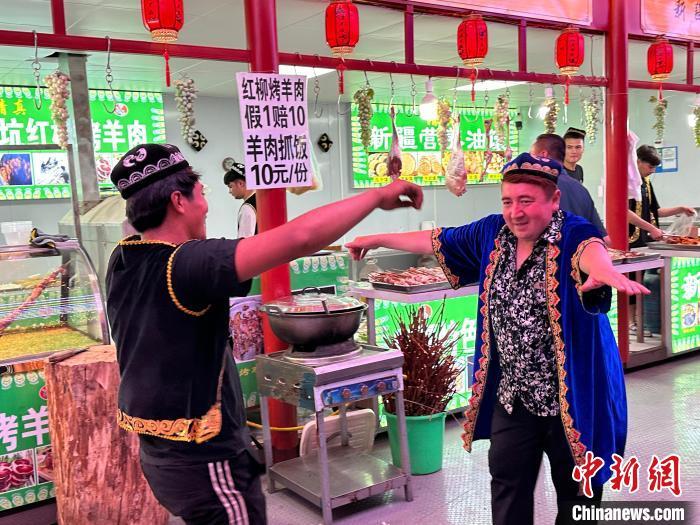 圖為餐飲經(jīng)營者在“西涼不夜城”跳起舞蹈引客?！〈魑牟?攝</p><p>