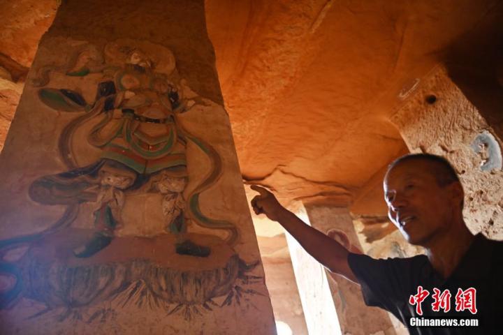 7月15日，甘肅省平?jīng)鍪袥艽h百里石窟長廊羅漢洞石窟內(nèi)，該窟文保員郭建平介紹窟內(nèi)石刻彩繪壁畫。郭建平家中三代人曾自發(fā)保護羅漢洞石窟。羅漢洞石窟遺存40余個窟龕，以北魏至清代風(fēng)格為主。中新社記者 李亞龍 攝</p>
<p>