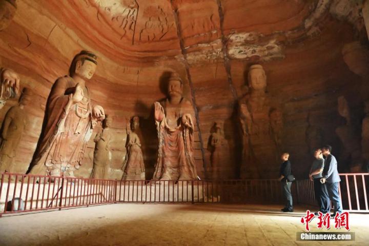 7月15日，游人參觀甘肅省平?jīng)鍪袥艽h百里石窟長廊中的南石窟寺1號窟。百里石窟長廊位于涇川縣境內(nèi)，由512個石窟、5眼窟中石井組成，現(xiàn)存王母宮石窟、鳳凰山石窟、南石窟寺、丈八寺石窟、羅漢洞石窟、太山寺石窟等規(guī)模較大的石窟群，還有數(shù)量眾多的小石窟群。南石窟寺開鑿于北魏永平三年，其中1號窟屬于大型七佛窟，七佛高達(dá)6米。中新社記者 李亞龍 攝