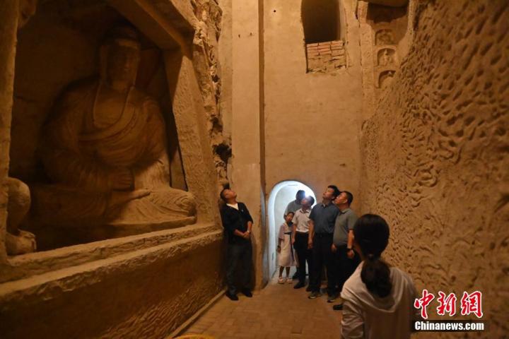 7月15日，游人參觀甘肅省平?jīng)鍪袥艽h百里石窟長廊中的王母宮石窟。百里石窟長廊位于涇川縣境內(nèi)，由512個石窟、5眼窟中石井組成，現(xiàn)存王母宮石窟、鳳凰山石窟、南石窟寺、丈八寺石窟、羅漢洞石窟、太山寺石窟等規(guī)模較大的石窟群，還有數(shù)量眾多的小石窟群。王母宮石窟又名千佛洞，該窟設(shè)計宏大，造像生動，窟內(nèi)擁有造像數(shù)百尊，是較為珍貴的佛教文化歷史遺存。中新社記者 李亞龍 攝</p>
<p>