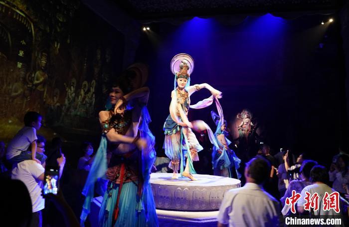 《樂動(dòng)敦煌》是全球首部洞窟式沉浸體驗(yàn)劇，利用真人與數(shù)字影像虛實(shí)交換實(shí)現(xiàn)沉浸式體驗(yàn)。圖為2023年8月28日晚，《樂動(dòng)敦煌》演出。(資料圖)中新社記者 毛建軍 攝