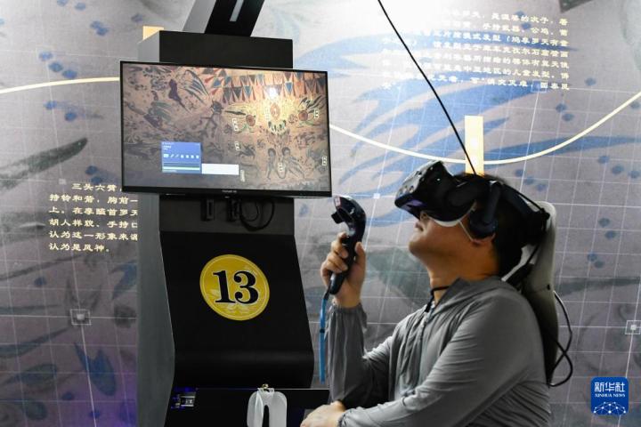7月22日，游客借助VR設(shè)備沉浸式游覽莫高窟第285窟虛擬場景。新華社記者 郎兵兵 攝